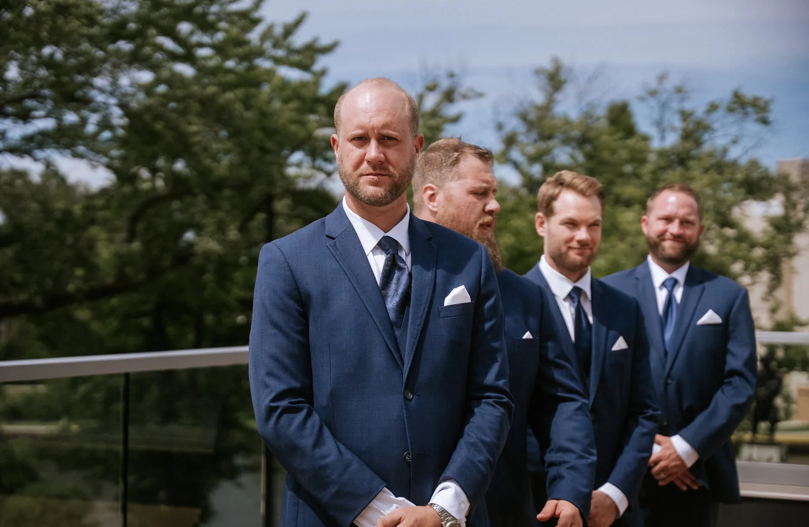 groomsmen standing at rooftop altar waiting
