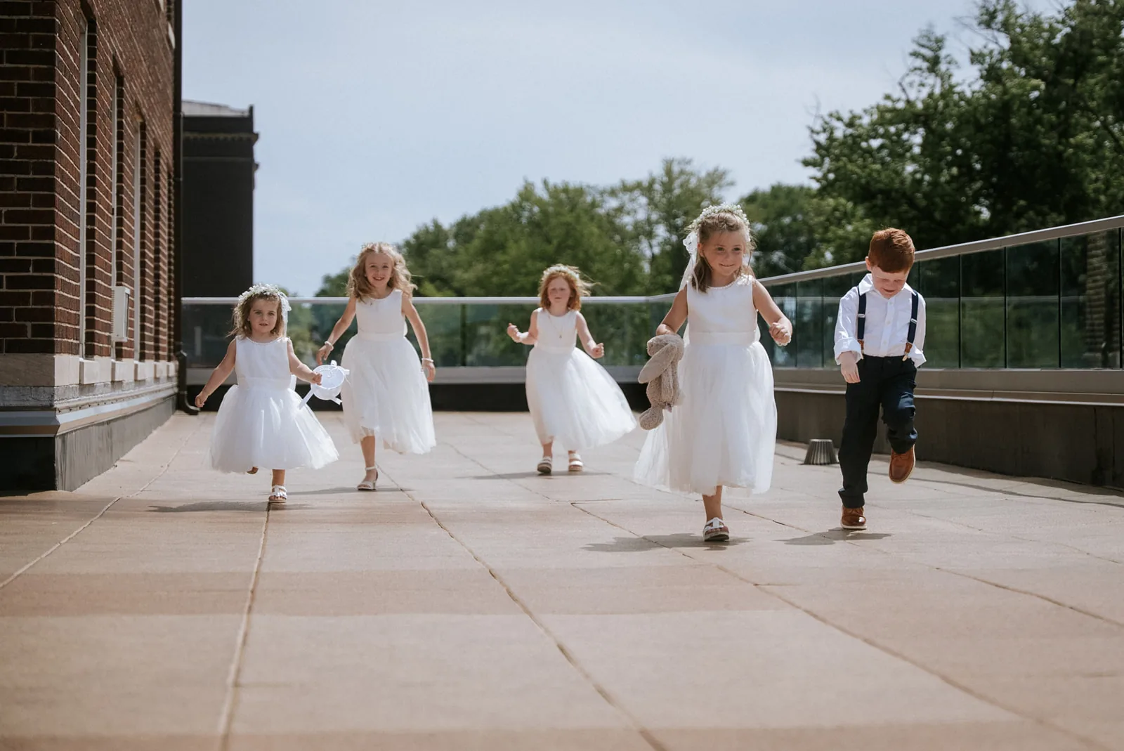 flower girls running playfully down rooftop aisle after ceremony
