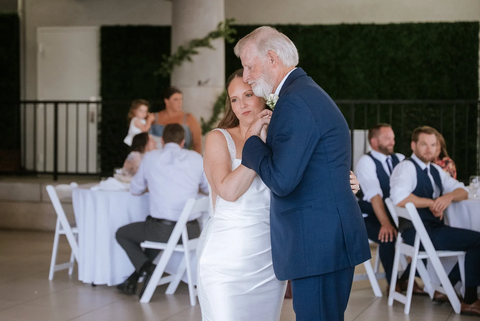 father-daughter dance at reception, guests seated around