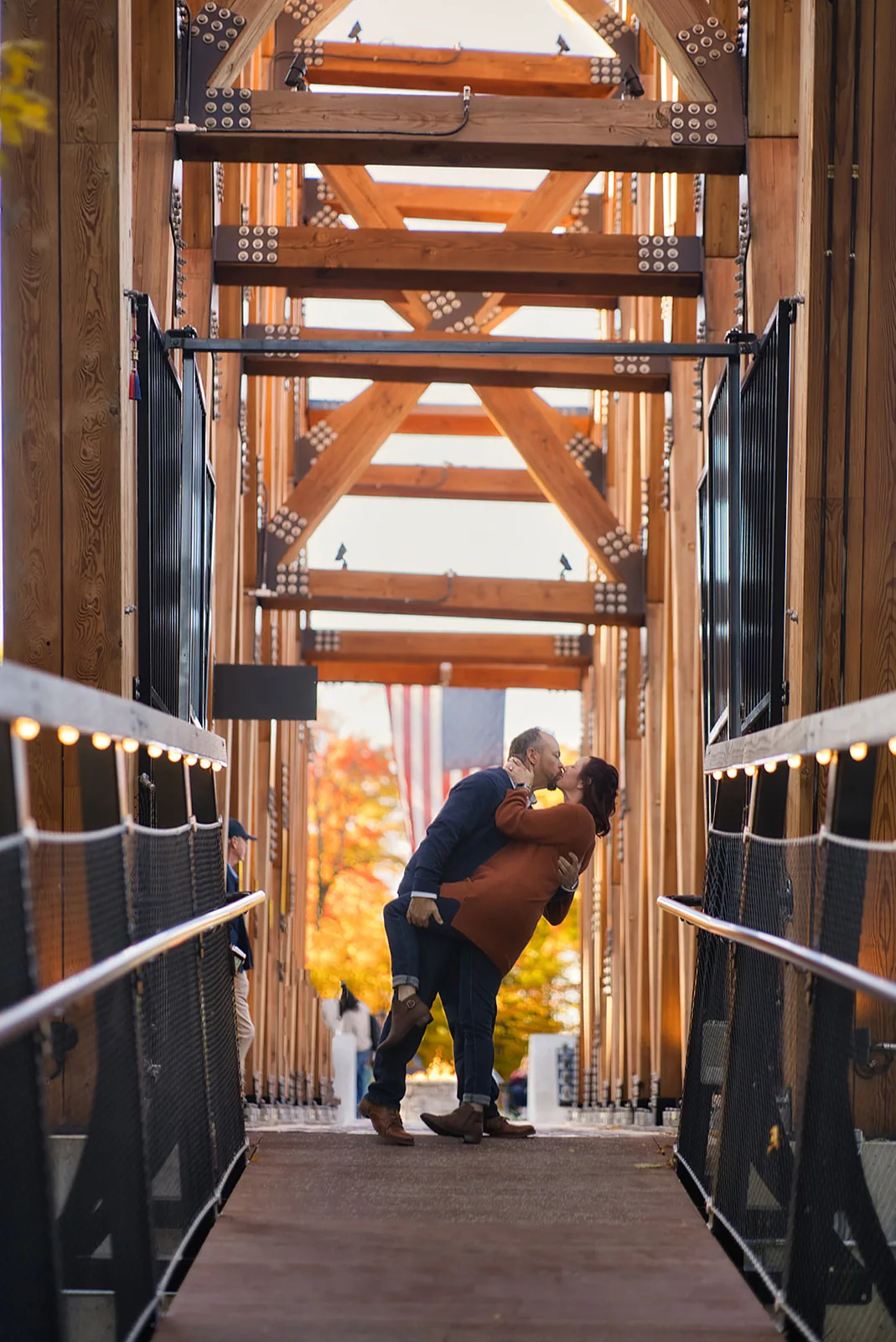 couple kissing, framed by wooden bridge tower structure