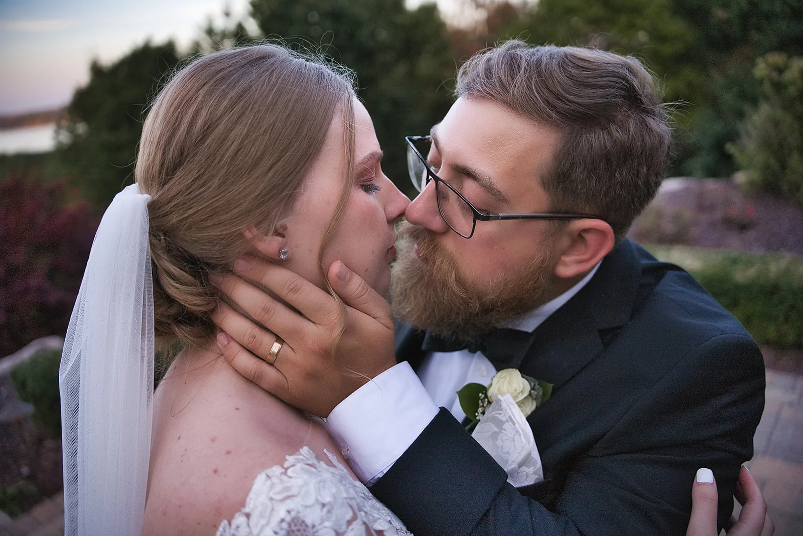 bride and groom close kiss portrait, golden hour, veil visible