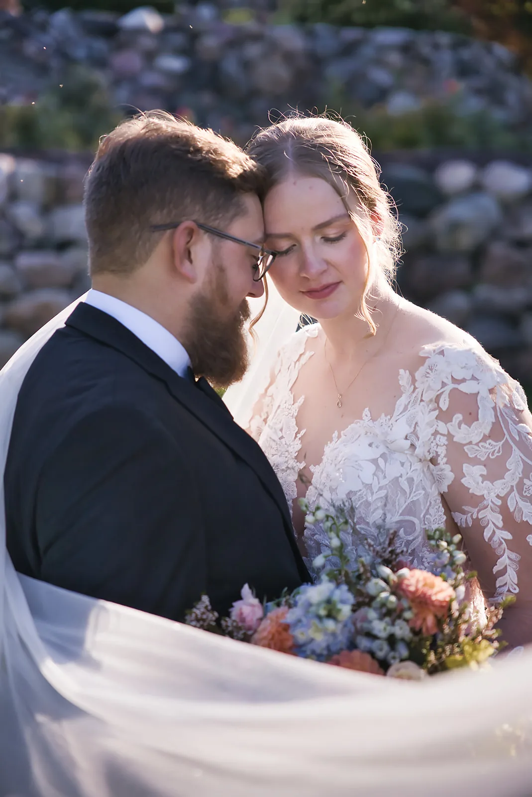 bride and groom close portrait, foreheads together, bouquet visible