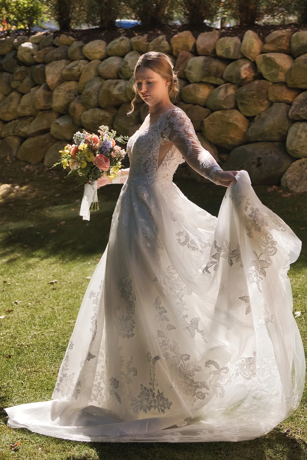 bride solo portrait smiling, bouquet, stone wall backdrop