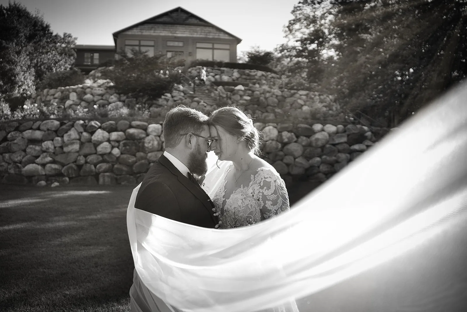 bw wide shot couple embracing on stone terrace overlooking venue