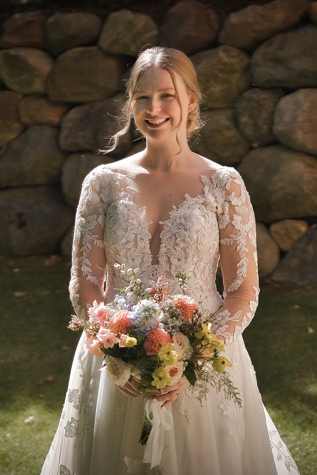 bride standing under long veil holding bouquet, outdoor