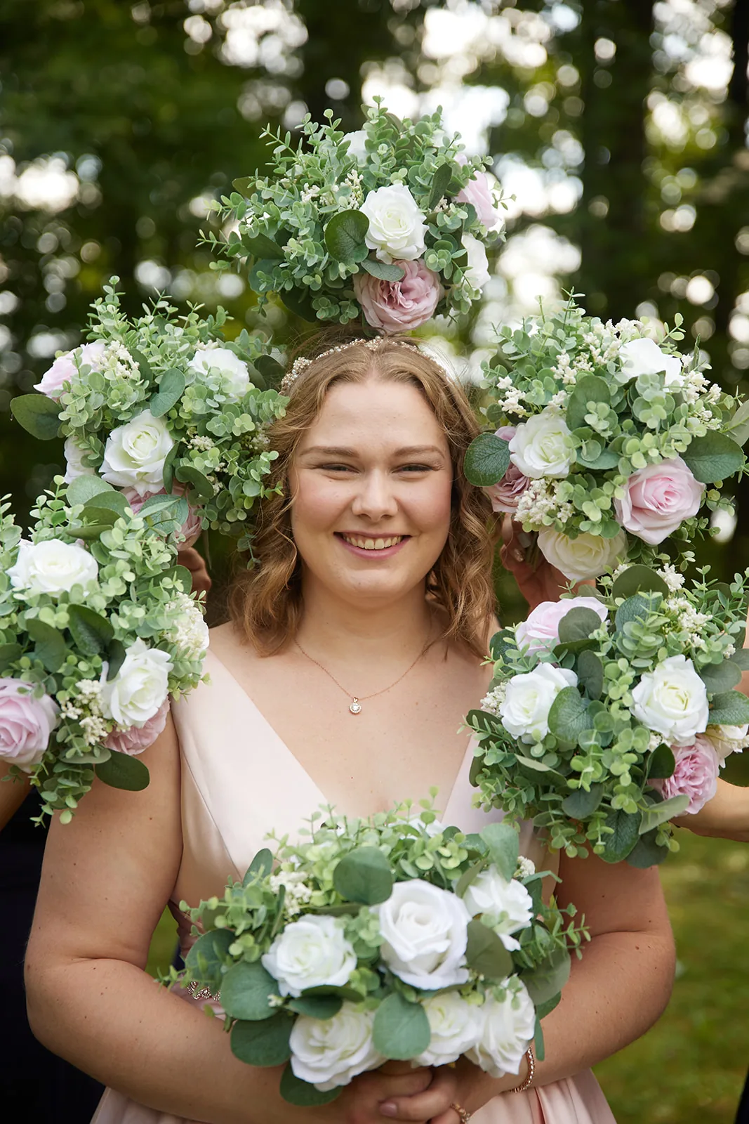 bride close portrait framed by bouquets held up around her face
