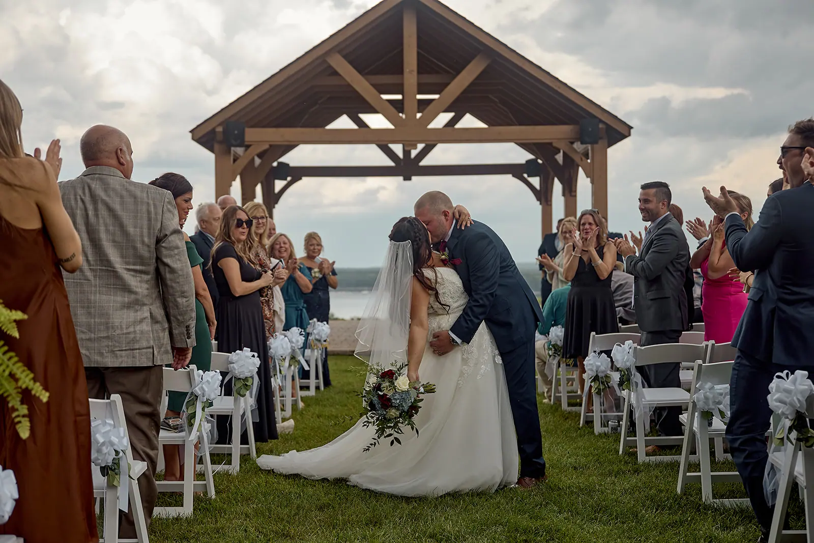 Couple walking back past pavilion guests — Taylor & Mark's wedding at The Manor at Fire Tower Hill, Lewiston, MI