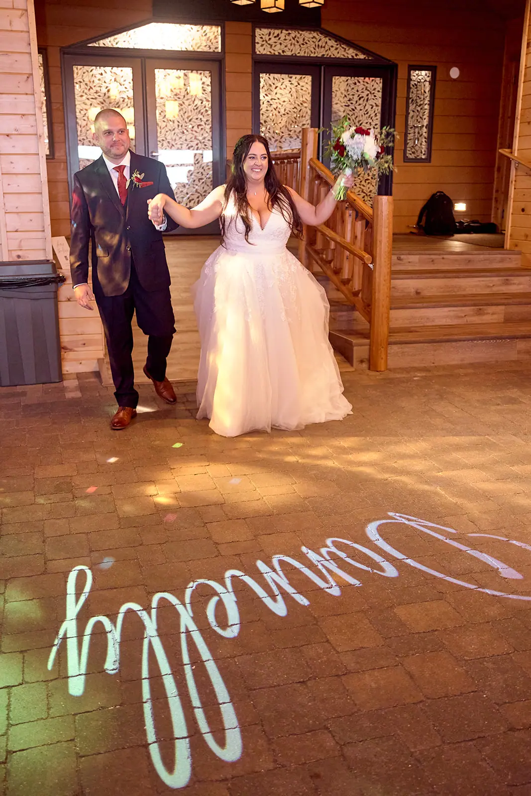Couple walking hall projected name bride — Taylor & Mark's wedding at The Manor at Fire Tower Hill, Lewiston, MI