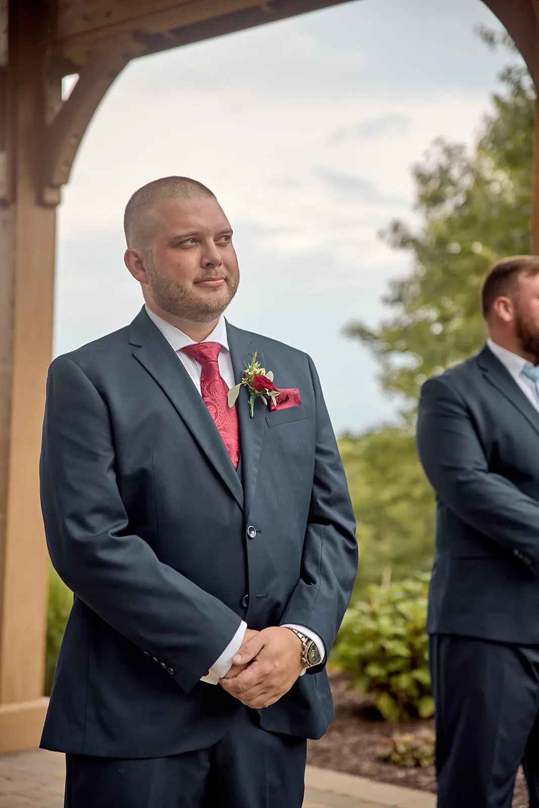 Groom arms folded pavilion lake — Taylor & Mark's wedding at The Manor at Fire Tower Hill, Lewiston, MI