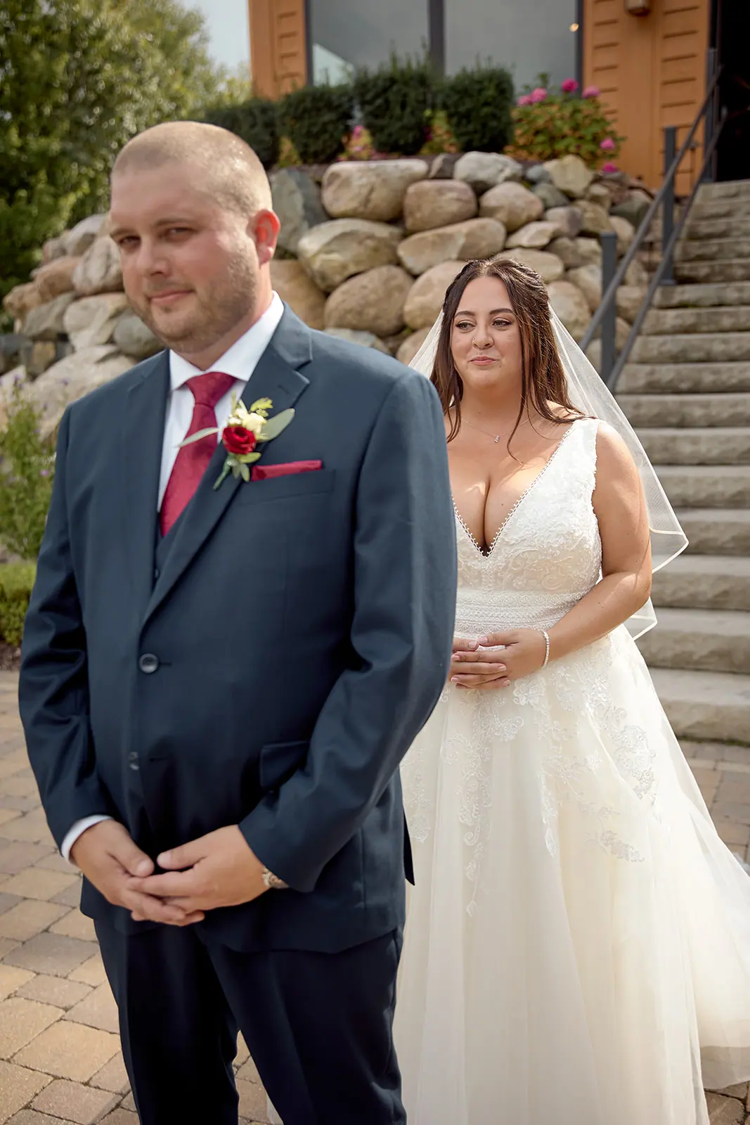 Groom hands clasped bride stone steps — Taylor & Mark's wedding at The Manor at Fire Tower Hill, Lewiston, MI