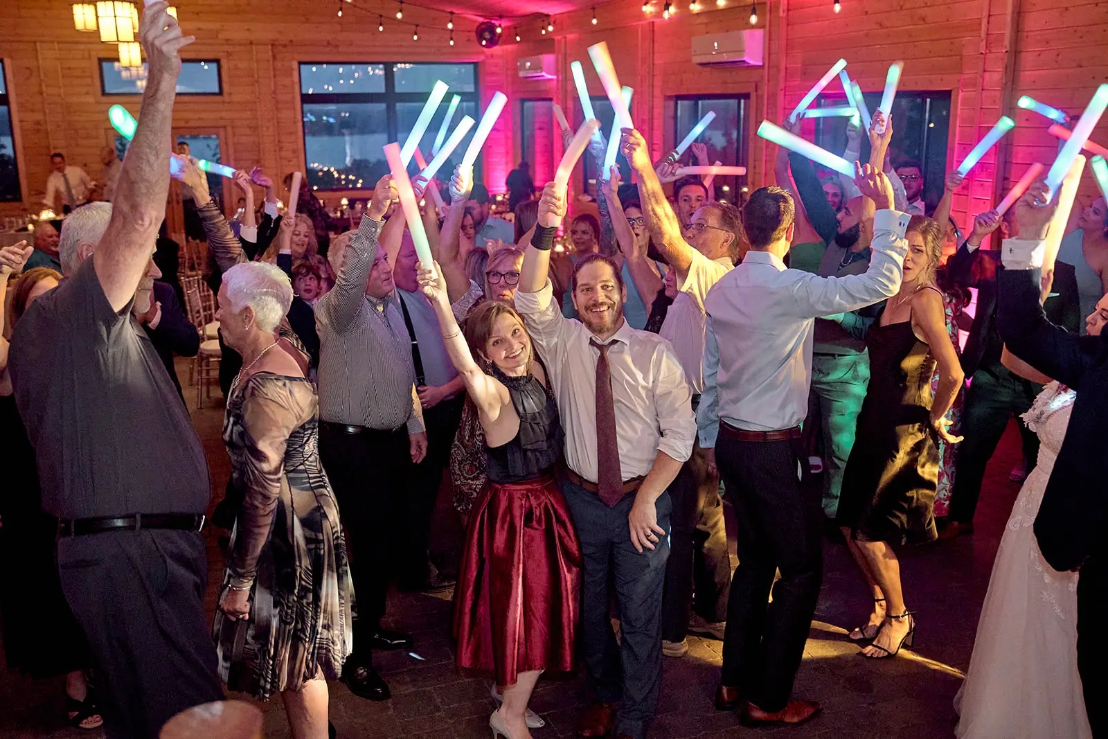Guests dancing light glow sticks reception — Taylor & Mark's wedding at The Manor at Fire Tower Hill, Lewiston, MI