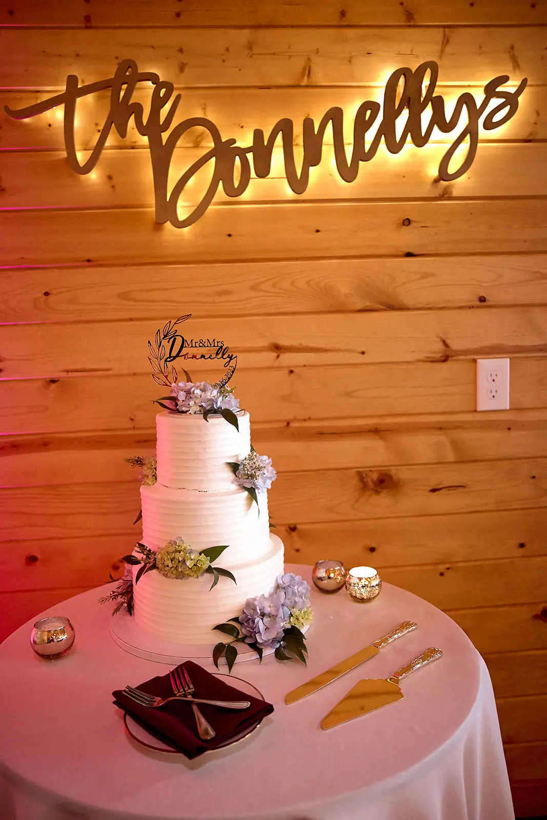 Lit donnellys sign above three tier — Taylor & Mark's wedding at The Manor at Fire Tower Hill, Lewiston, MI