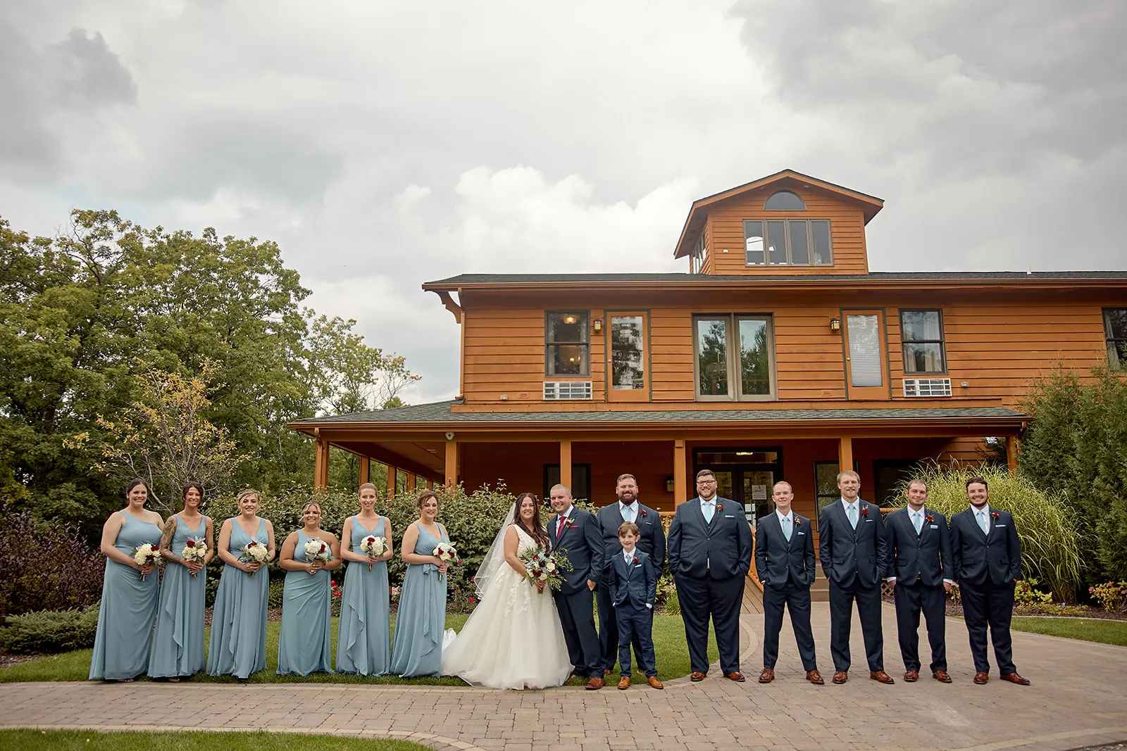 Wedding party standing front lodge bride — Taylor & Mark's wedding at The Manor at Fire Tower Hill, Lewiston, MI