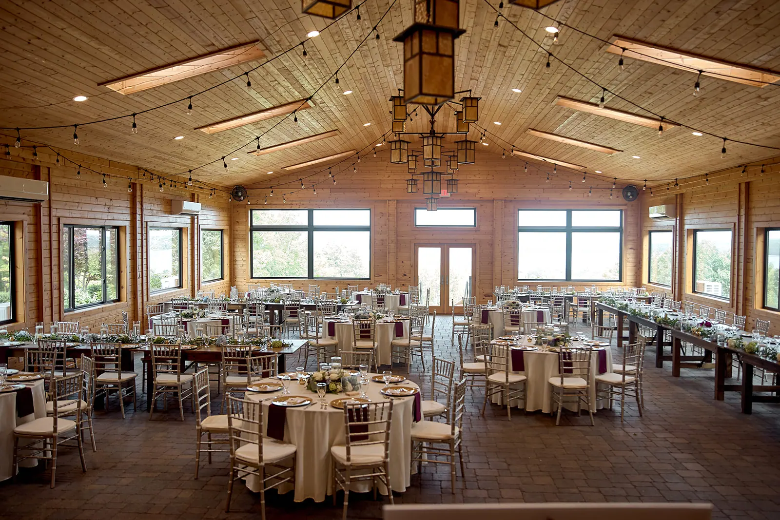Wide reception hall string lights round — Taylor & Mark's wedding at The Manor at Fire Tower Hill, Lewiston, MI